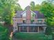 Charming brick home featuring a large porch with screened section and lush surrounding greenery at 209 Tinkham Trl, Cramerton, NC 28032