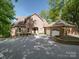 Inviting brick home featuring an attached two-car garage and a wide driveway at 209 Tinkham Trl, Cramerton, NC 28032