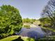 Scenic golf course view with a pond and lush green landscaping at 209 Tinkham Trl, Cramerton, NC 28032