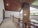 Bright hallway with wood ceiling and stone fireplace, featuring a wooden railing at 209 Tinkham Trl, Cramerton, NC 28032