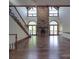 Elegant living room with a stone fireplace, hardwood floors, and staircase at 209 Tinkham Trl, Cramerton, NC 28032