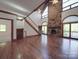 Bright living room with stone fireplace, wooden floors, and staircase at 209 Tinkham Trl, Cramerton, NC 28032