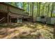 This backyard features a deck with stairs, an HVAC, two storage sheds, and a wooded lot at 211 W Tennessee Ave, Bessemer City, NC 28016