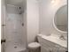 Clean bathroom featuring a walk-in shower, a round mirror, and a vanity with modern fixtures at 211 W Tennessee Ave, Bessemer City, NC 28016