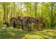 Exterior of home featuring a fenced yard with lush greenery and natural landscaping surrounded by mature trees at 211 W Tennessee Ave, Bessemer City, NC 28016