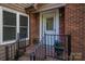Close-up of the front entrance featuring a brick exterior, decorative glass door, and welcoming potted plants at 211 W Tennessee Ave, Bessemer City, NC 28016