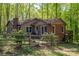 View of home's exterior showing fenced yard and deck surrounded by lush, mature trees for privacy at 211 W Tennessee Ave, Bessemer City, NC 28016