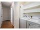Bright laundry room with washer, dryer, and storage shelves, enhancing functionality and organization at 211 W Tennessee Ave, Bessemer City, NC 28016