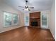 The cozy living room features a brick fireplace and multiple windows for ample natural light at 211 W Tennessee Ave, Bessemer City, NC 28016