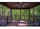 Relaxing screened porch with wood flooring and ceiling fan overlooks a lush, wooded backyard at 211 W Tennessee Ave, Bessemer City, NC 28016