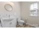 Well-lit half bathroom featuring a sleek vanity with a round mirror and white subway tile at 21907 Torrence Chapel Rd, Cornelius, NC 28031