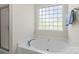 Bright bathroom featuring a soaking tub, glass block window, and a separate shower at 21907 Torrence Chapel Rd, Cornelius, NC 28031