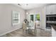 Dining area featuring a glass table, white chairs, and double doors to the outdoor deck at 21907 Torrence Chapel Rd, Cornelius, NC 28031