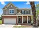 Charming two-story home featuring a brick facade, a welcoming front porch with rocking chairs, and a well-maintained lawn at 21907 Torrence Chapel Rd, Cornelius, NC 28031