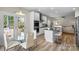 Bright kitchen with white cabinets, stainless appliances, island, and adjacent dining area with deck access at 21907 Torrence Chapel Rd, Cornelius, NC 28031