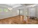 Bright, open-concept living space with hardwood floors, abundant natural light, and modern chandelier at 21907 Torrence Chapel Rd, Cornelius, NC 28031