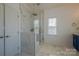 Bright bathroom featuring a glass shower with marble surround, and blue vanity at 2380 Fairport Se Dr, Concord, NC 28025