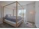 Bright bedroom with a four-poster bed, neutral carpet, and a large window for natural light at 2380 Fairport Se Dr, Concord, NC 28025