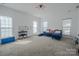 Spacious bonus room with ample natural light, neutral carpet, and bright white walls at 2380 Fairport Se Dr, Concord, NC 28025