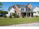 Charming two-story home with a mix of stone and wood siding, lush lawn, and inviting front porch at 2380 Fairport Se Dr, Concord, NC 28025