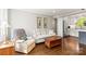 Bright living room with hardwood floors, comfortable furnishings, and stainless steel appliances in the kitchen at 241 Wakefield Dr # C, Charlotte, NC 28209