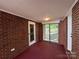 The sun room has brick walls, carpeted floors, windows, and a ceiling light at 2703 34Th Street Ne Pl, Hickory, NC 28601