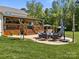 Outdoor living space features a covered deck, dining area, a hot tub, and a well-manicured lawn at 3008 Gantt St, Salisbury, NC 28146