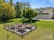 Landscaped garden featuring raised garden beds, a gravel walkway and lush green grass. Adjacent to the house and garage at 3008 Gantt St, Salisbury, NC 28146