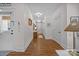 Hallway with white walls, wood floors, decorative mirrors, and a view towards a bright window at 3008 Gantt St, Salisbury, NC 28146