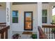 Inviting front porch with a black framed door, side windows, and brown wood railing and posts at 3121 Suffolk Dr, Shelby, NC 28152