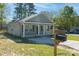 Single-story home featuring gray siding, black shutters, green lawn, and covered porch at 402 Digh St, Gastonia, NC 28052