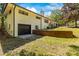The backyard featuring a charming brick exterior and a black garage door surrounded by lush greenery at 4110 Charles Raper Jonas Hwy, Alexis, NC 28006