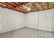 Unfinished basement with a painted cinder block wall offering possibilities for future home improvements at 4110 Charles Raper Jonas Hwy, Alexis, NC 28006