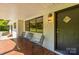 Close up of the covered porch entrance with three chairs and black door at 4110 Charles Raper Jonas Hwy, Alexis, NC 28006