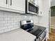 Modern kitchen features stainless steel appliances, white cabinets, gray counters, and subway tile backsplash at 424 Fulton Dr, Kings Mountain, NC 28086