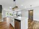 Open-concept living space with kitchen island, fireplace, light-colored walls, and wood-look floors at 424 Fulton Dr, Kings Mountain, NC 28086