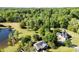 Overhead shot showcases a well-maintained home and large lot with a pond, surrounded by lush trees and greenery at 459 Cramerton Rd, Gastonia, NC 28056