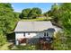 Back exterior view of home with a spacious deck and partially fenced yard surrounded by mature trees at 459 Cramerton Rd, Gastonia, NC 28056