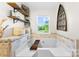 Relaxing soaking tub with a view and decorative shelving in the primary bathroom at 459 Cramerton Rd, Gastonia, NC 28056