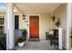 Cozy front porch featuring a bright orange door, decorative accents, bench, and fresh greenery at 459 Cramerton Rd, Gastonia, NC 28056