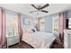 Comfortable bedroom with a ceiling fan, soft pink accents, and natural light from two windows at 4607 Bonroi Ave, Charlotte, NC 28213