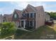 Brick and siding house boasts a well-maintained yard with green grass, mature trees, and an attached two-car garage at 4607 Bonroi Ave, Charlotte, NC 28213