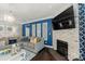 Cozy living area with a stone fireplace, mounted TV, dark wood floors, and a plush gray sofa at 4607 Bonroi Ave, Charlotte, NC 28213