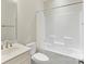 Well-lit bathroom featuring a modern vanity, toilet, and tub/shower combo with white tiles at 4991 Looking Glass Trl, Denver, NC 28037