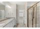 Bathroom features a double sink vanity, granite countertop, and tiled shower with gold trim at 4991 Looking Glass Trl, Denver, NC 28037