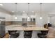 A modern kitchen with white cabinets, an island with barstools, and stainless steel appliances at 4991 Looking Glass Trl, Denver, NC 28037