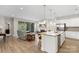 Open-concept kitchen and living room with island, fireplace, and sliding glass doors at 4991 Looking Glass Trl, Denver, NC 28037