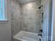 Bathroom featuring white tub with black fixtures and white marble tiling at 5006 Mclaughlin Dr # 103, Waxhaw, NC 28173