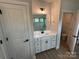 Bathroom with sink vanity featuring white cabinets, quartz countertop, black hardware, and an open toilet area at 5006 Mclaughlin Dr # 103, Waxhaw, NC 28173