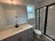 Modern bathroom with sleek vanity, glass shower stall, subway tiles and natural light from the window at 5006 Mclaughlin Dr # 103, Waxhaw, NC 28173